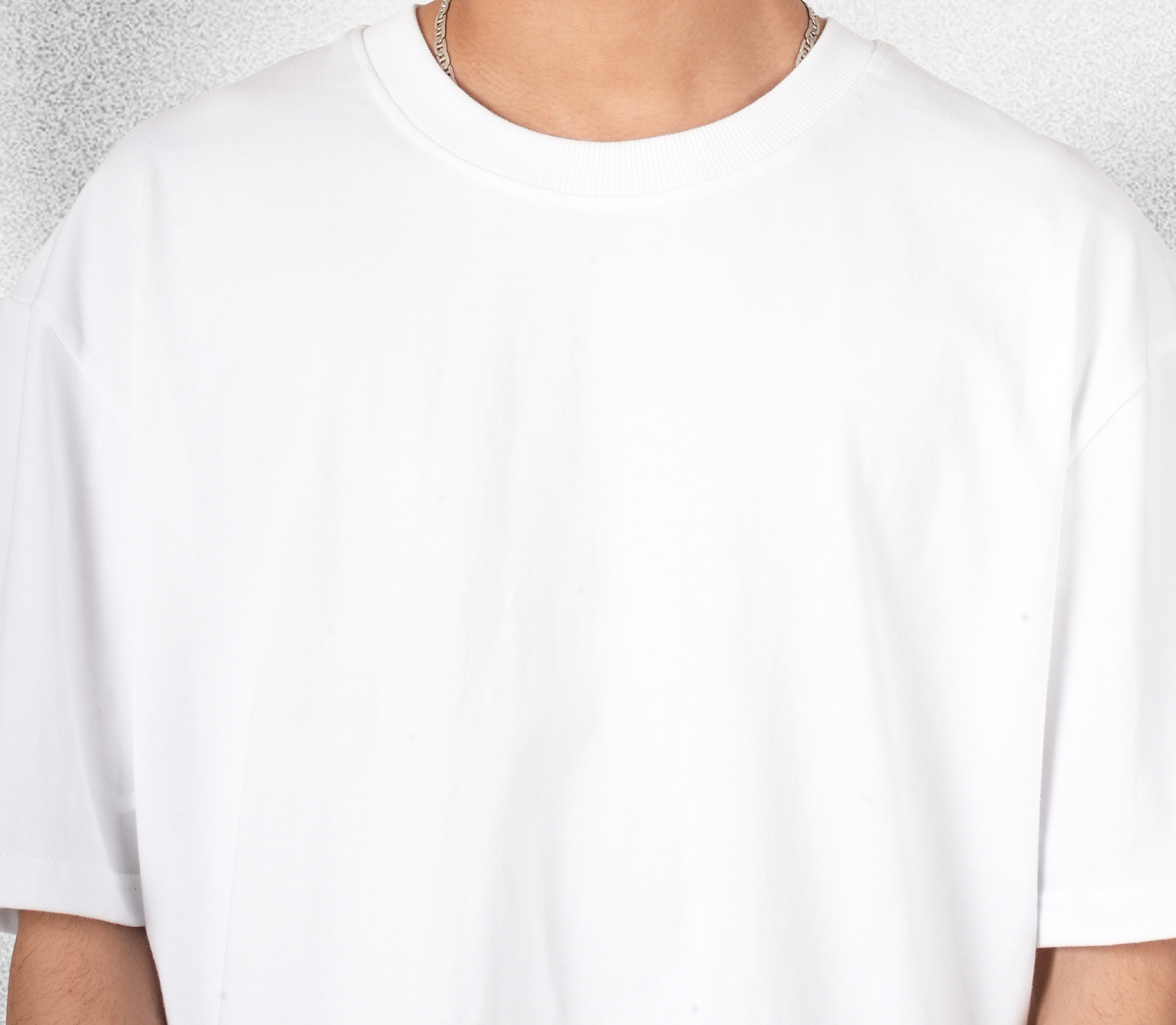 White t-shirt worn by a person with a neutral background