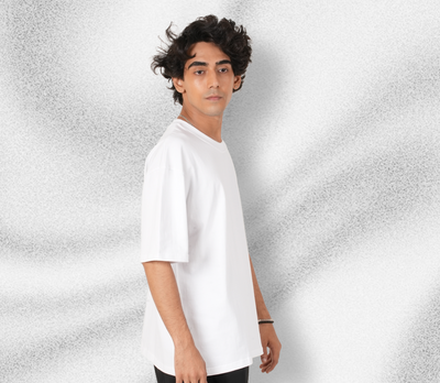 Person wearing a white t-shirt against a textured gray background