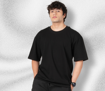 Person wearing a black t-shirt against a textured gray background