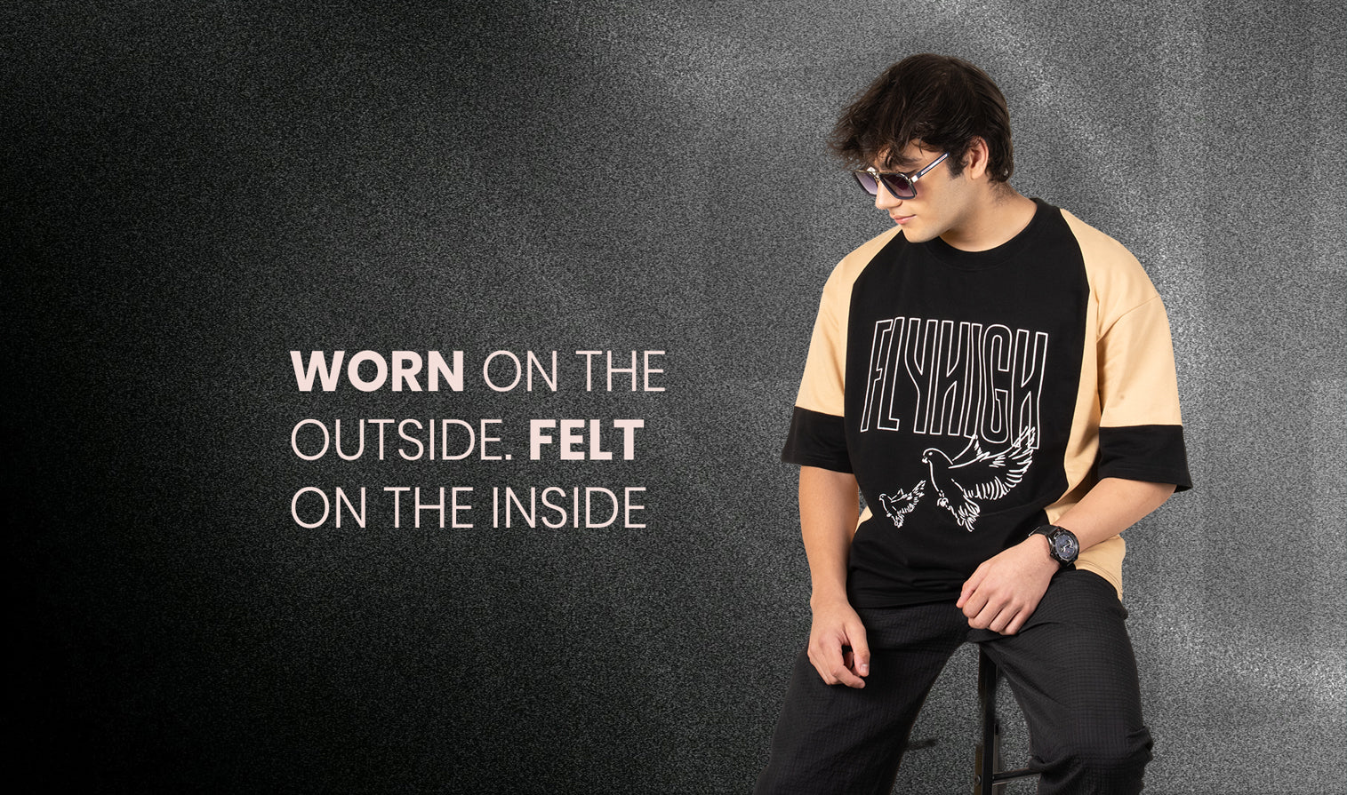 Person wearing a black and beige t-shirt with 'FLYHIG' branding against a dark background.