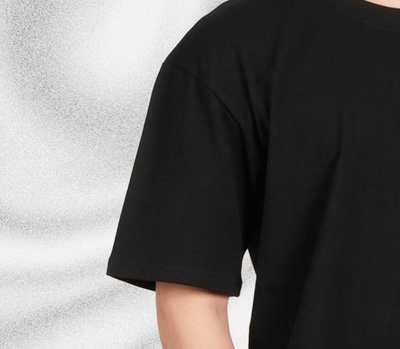 Black oversized t-shirt worn by a person on a light gray background